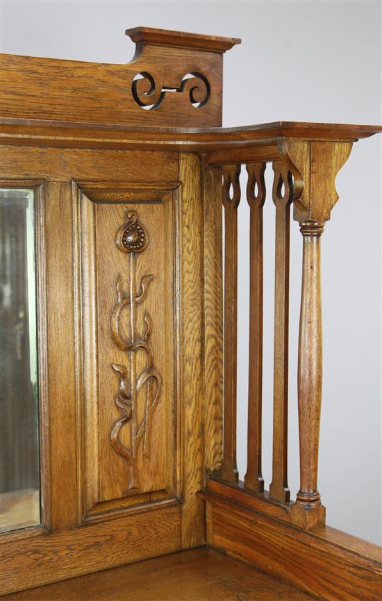 An Arts & Crafts carved oak sideboard with raised mirrored back, W. 5ft 8in. D. 1ft 11in. H. 6ft 4in.